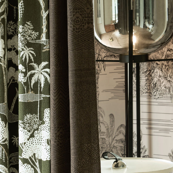 Close-up of LOOM blackout curtain fabric showing dual-layer construction with intricate jacquard texture and natural-themed lining for enhanced room ambiance.

