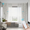 STRONA custom motorized blackout curtains in ripplefold style, shown in a minimalist bedroom with floor-to-ceiling windows. Smart control via handheld remote for smooth operation.