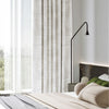 STRONA ripplefold curtains in soft textured gray, blending with modern bedroom decor. Light-filtering design with full blackout lining for restful sleep and elegant style.

