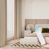 Modern bedroom with smart curtians, white rug, and person holding a remote control.